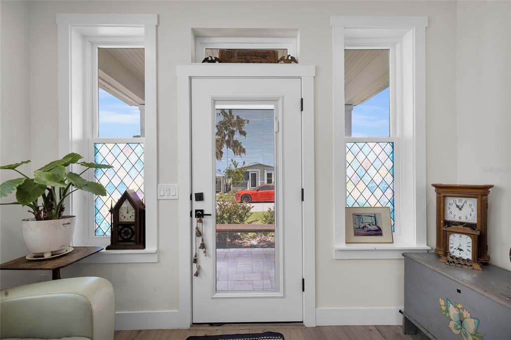 A white front door with a glass insert is flanked by two windows with decorative panes — 12039 LAKESHORE WAY, OXFORD, FL