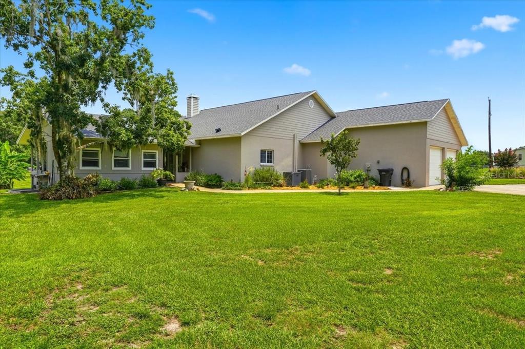 A single-story house with gray siding, a shingled roof, and an attached two-car garage — 8404 MATHEWS ROAD, LAKELAND, FL