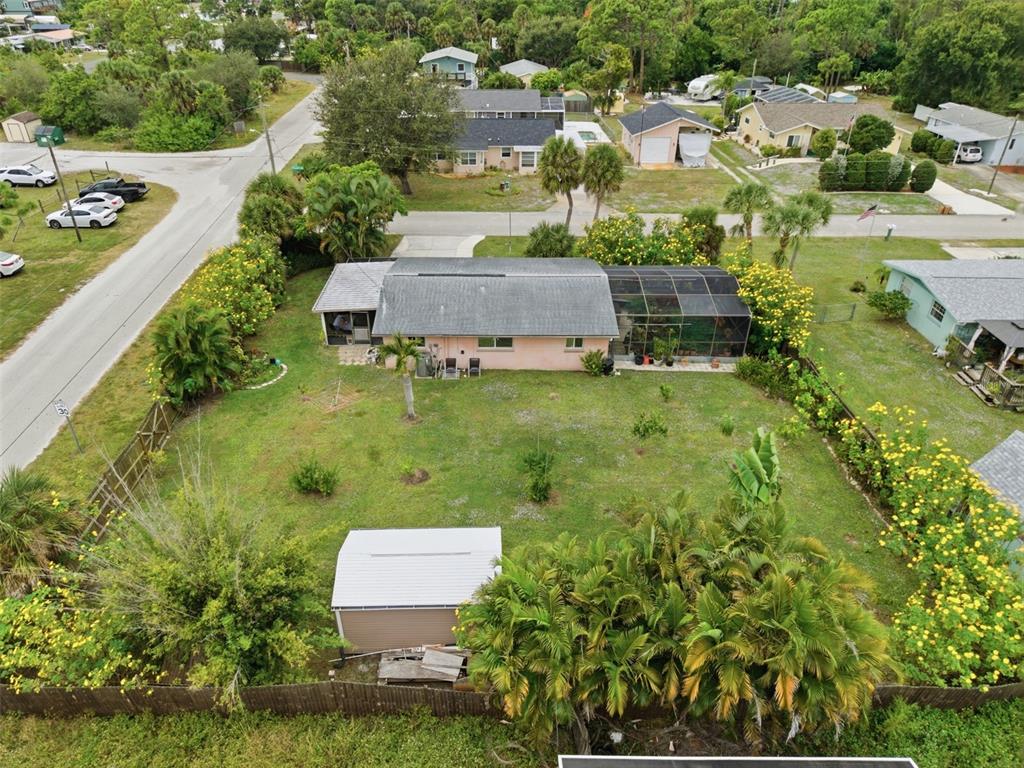 An aerial view shows a pink house with a screened-in porch and a detached shed — 857 PALMETTO STREET, ENGLEWOOD, FL