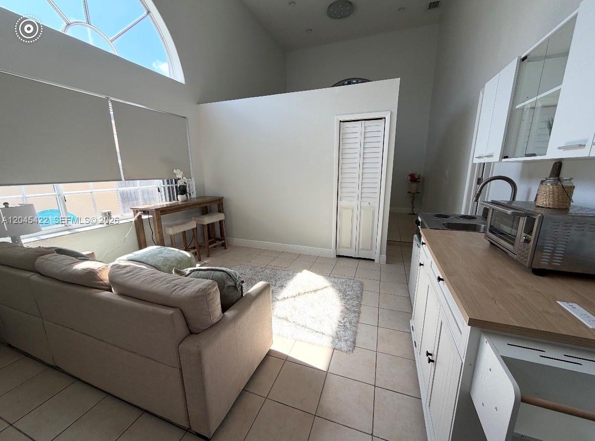 This studio apartment features a kitchenette, a living area, and a high vaulted ceiling — 8277 NW 194th Ter # 2, Hialeah FL 33015, HIALEAH, FL