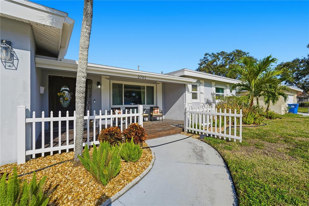A single-story house features a white picket fence, a front porch, and a walkway — 2701 64TH AVENUE S, ST PETERSBURG, FL