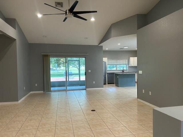 An open-concept living area features tile flooring, a ceiling fan, and a view of a patio — 1301 SW 83rd Avenue, Okeechobee FL 34974, OKEECHOBEE, FL