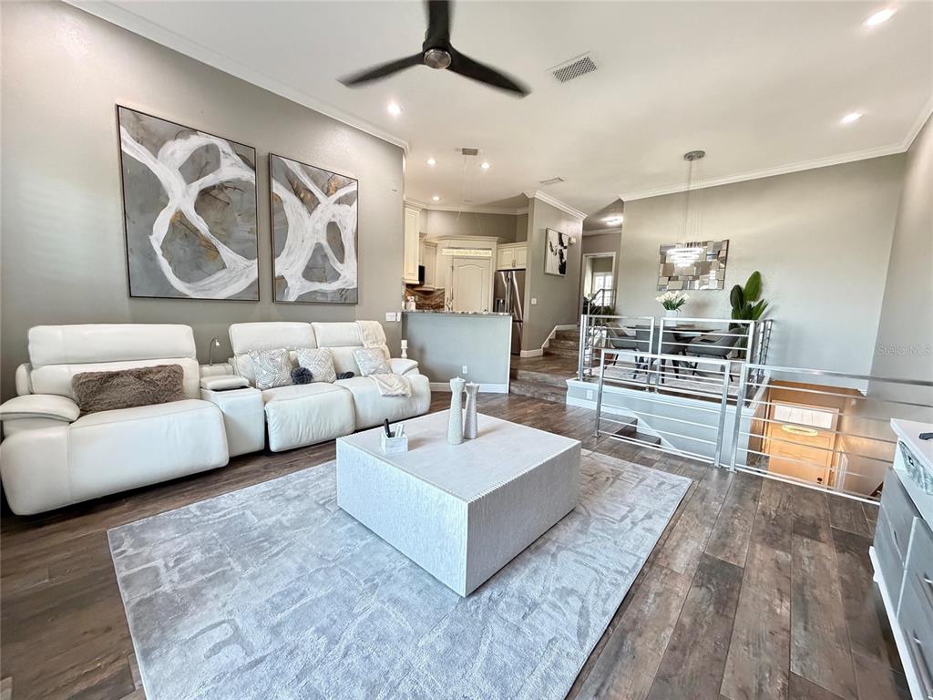 A multi-story apartment building with beige stucco siding, multiple garage doors, and surrounding trees — 756 CORAL REEF DRIVE, TAMPA, FL