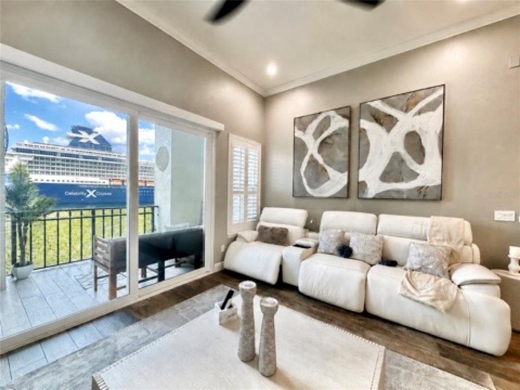 A living room with a white sofa faces a balcony overlooking a large cruise ship — 756 CORAL REEF DRIVE, TAMPA, FL