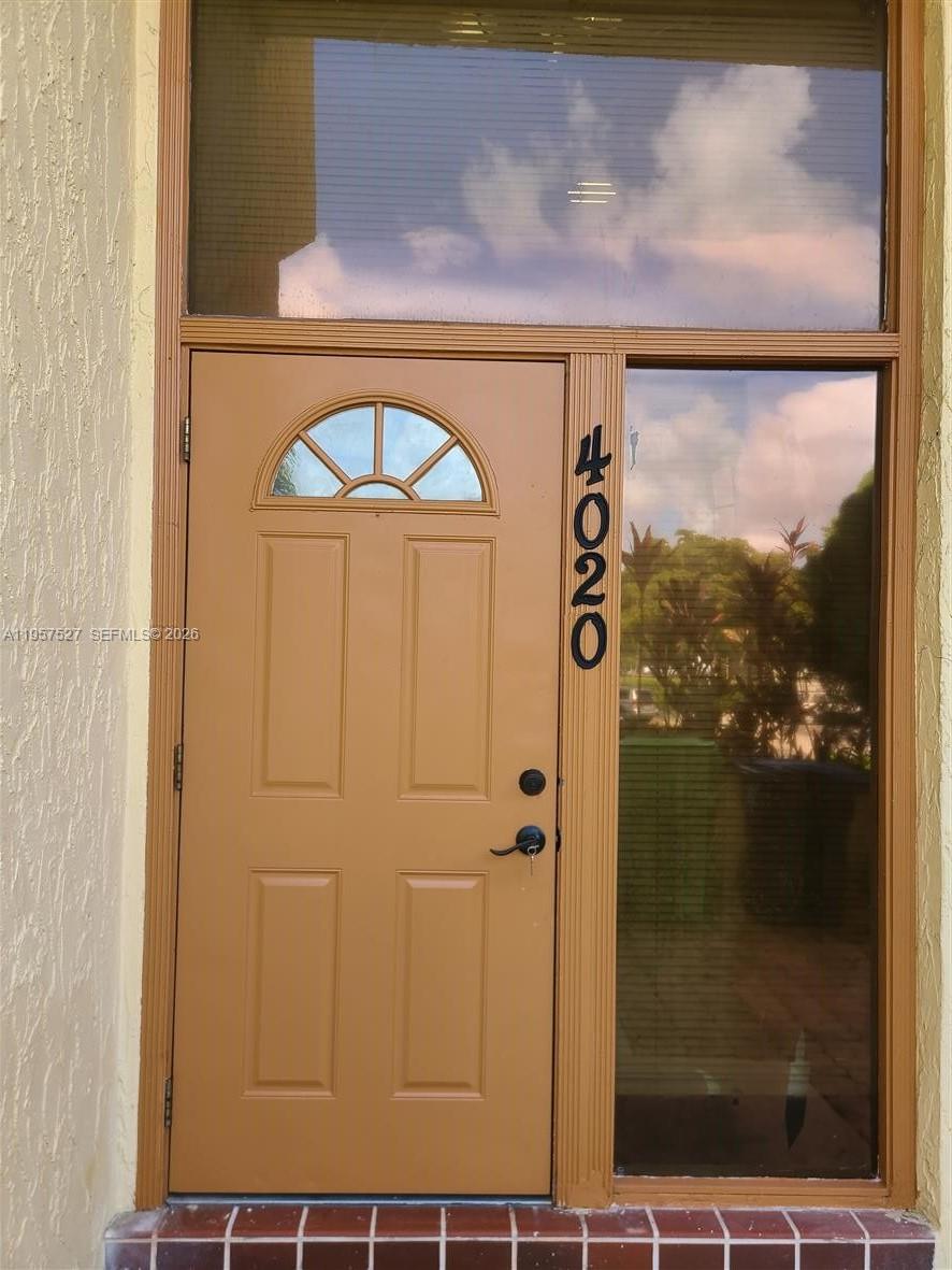 A brown front door with a small arched window and vertical house numbers — 4020 Del Rio Way # 720, Sunrise FL 33351, SUNRISE, FL