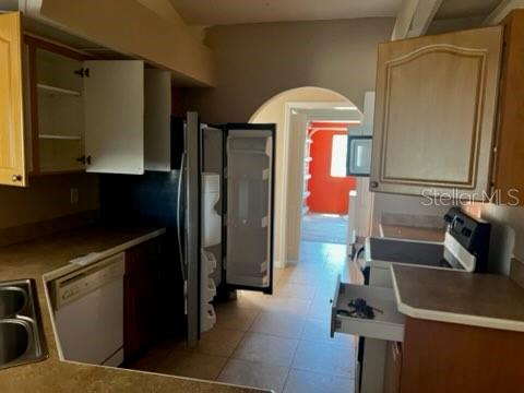 A kitchen with wood cabinets, a stainless steel refrigerator, and a dishwasher — 220 PALMETTO CIRCLE NE, PORT CHARLOTTE, FL