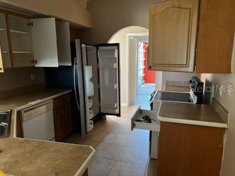 A kitchen with light wood cabinets, a dishwasher, an open refrigerator, and tile flooring — 220 PALMETTO CIRCLE NE, PORT CHARLOTTE, FL