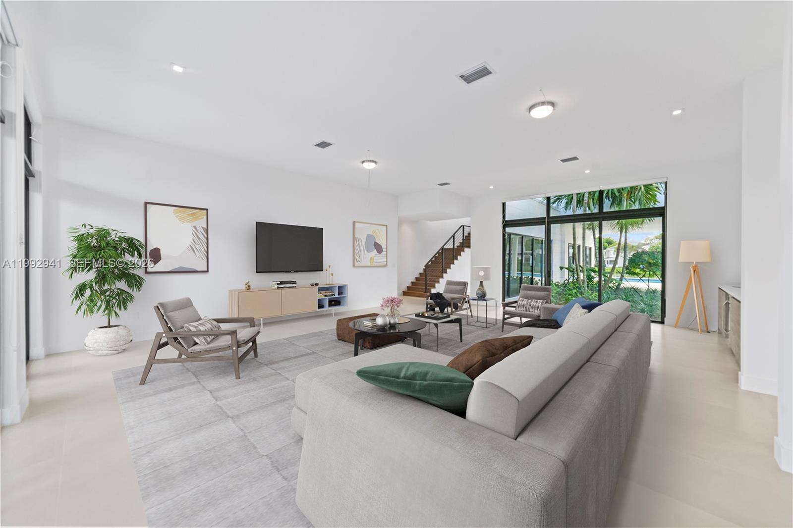 A modern living room features a large gray sectional, a television, and floor-to-ceiling windows — 16680 N Botaniko Dr N # 16680, Weston FL 33326, WESTON, FL