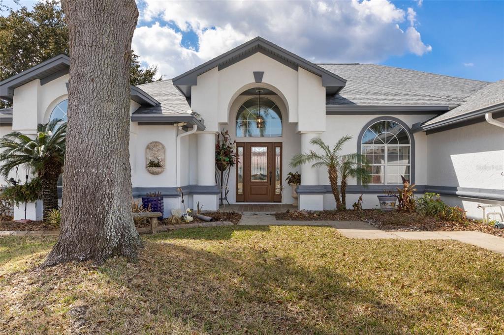 A single-story house with a gray garage, arched windows, and an inset pool photo — 10 CHELSEA COURT, PALM COAST, FL