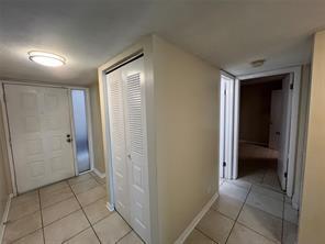 An entryway with tile flooring, a louvered closet door, and a view into a hallway — 8040 Hampton Boulevard # 104, North Lauderdale FL 33068, NORTH LAUDERDALE, FL