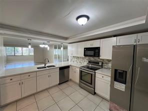 A kitchen with white cabinets, stainless steel appliances, and tile flooring — 8040 Hampton Boulevard # 104, North Lauderdale FL 33068, NORTH LAUDERDALE, FL