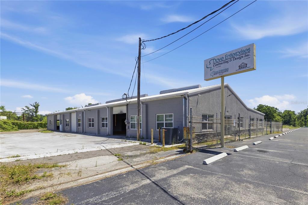A gray commercial building with a paved parking lot and a prominent business sign — 943 NW 17TH AVENUE, OCALA, FL