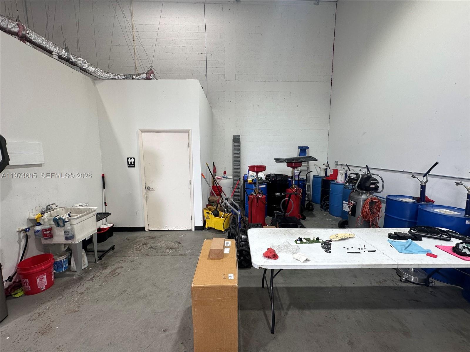 An industrial workshop space features a utility sink, a folding table, and various equipment — 3136 John P Curci Dr, Hallandale Beach FL 33009, HALLANDALE BEACH, FL
