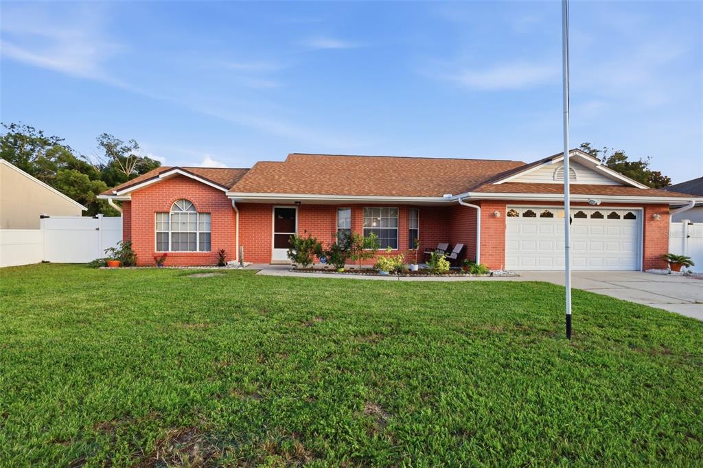 A backyard features a house with a tan roof, a gazebo, and a white fence — 2287 BELEN DRIVE, DELTONA, FL