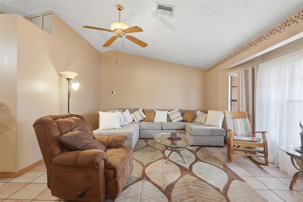 A backyard view of a house with a white fence and a metal gazebo — 2287 BELEN DRIVE, DELTONA, FL