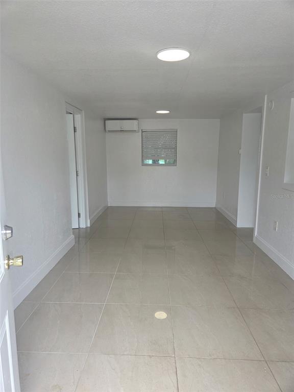 An interior view of a room with white walls, light-colored tile flooring, and a window — 5930 ALLIGATOR LAKE SHORE W UNIT A2, ST CLOUD, FL