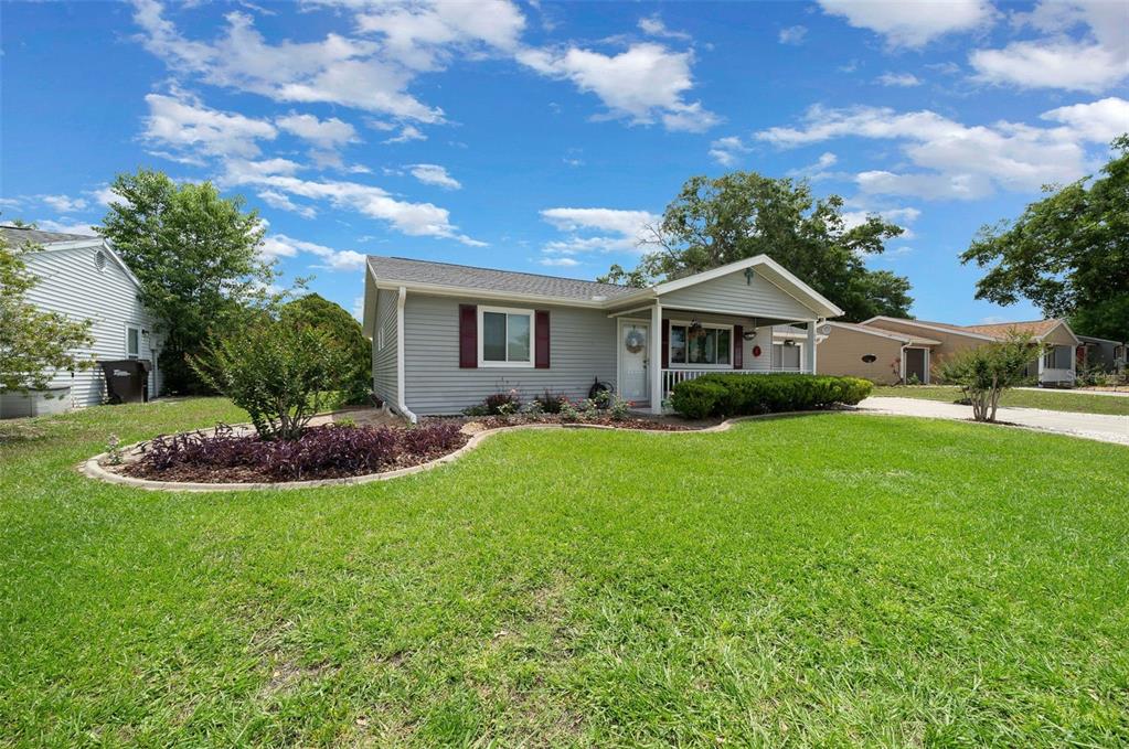 A single-story house with gray siding, a front porch, and a landscaped yard — 10821 SW 87TH TERRACE, OCALA, FL