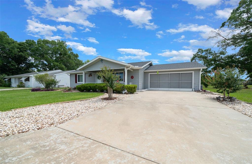 A single-story house with gray siding, a concrete driveway, and a screened-in garage — 10821 SW 87TH TERRACE, OCALA, FL