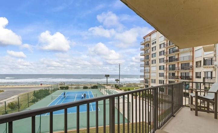 A balcony view overlooking a tennis court and the ocean next to a high-rise building — 3600 OCEAN SHORE BOULEVARD UNIT 311, FLAGLER BEACH, FL