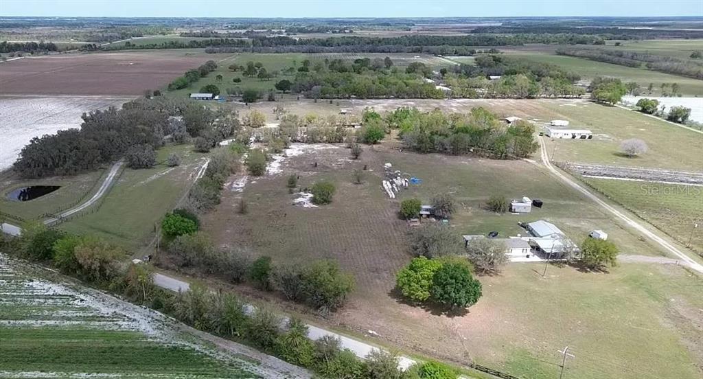 An aerial view shows a rural property with a house, outbuildings, and surrounding pasture land — 30620 TAYLOR GRADE ROAD, DUETTE, FL