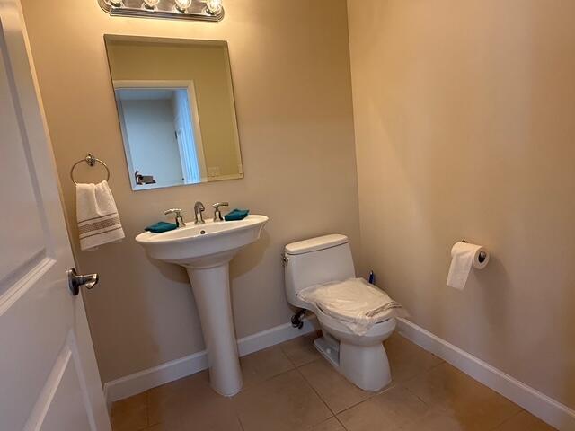 A small bathroom features a pedestal sink, a toilet with a plastic-covered seat, and a mirror — 1945 S Ocean Drive # 509, Hallandale Beach FL 33009, HALLANDALE BEACH, FL