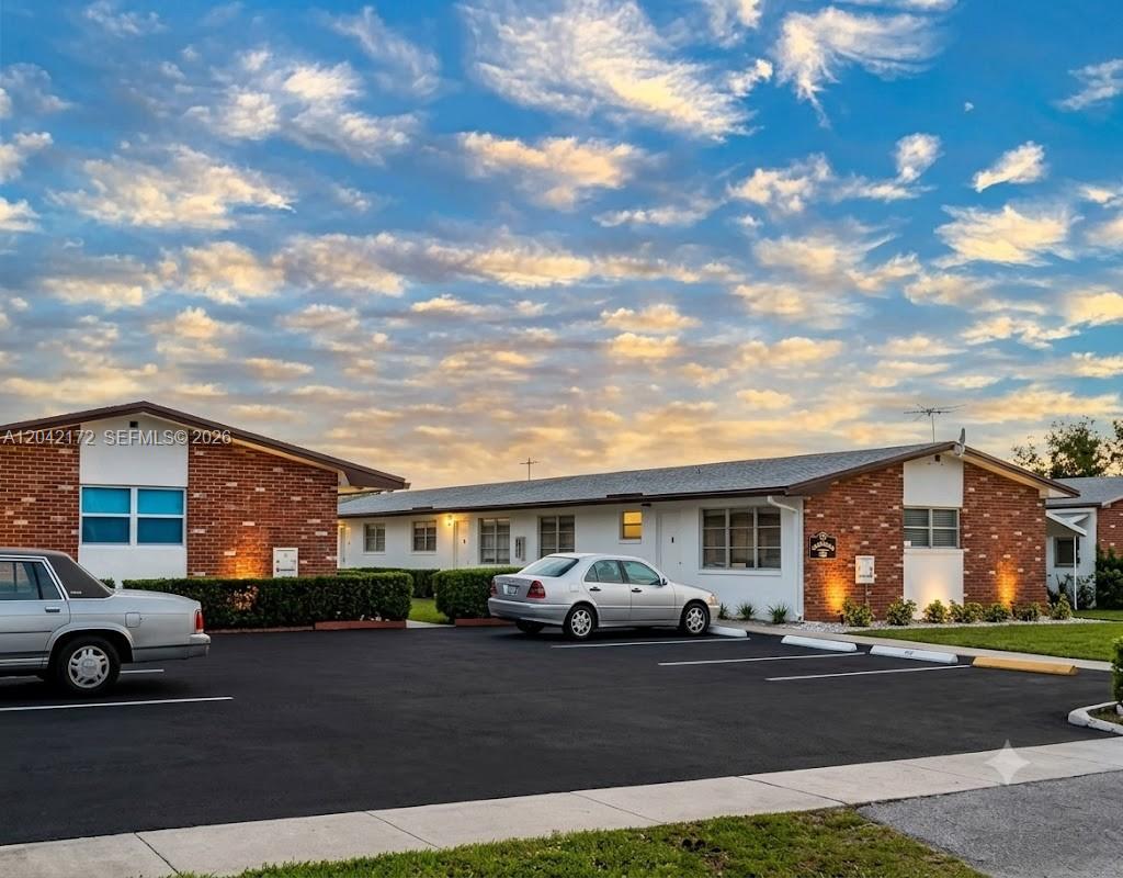 A one-story brick and white apartment building with a parking lot in front — 2230 Jackson St # 1W, Hollywood FL 33020, HOLLYWOOD, FL
