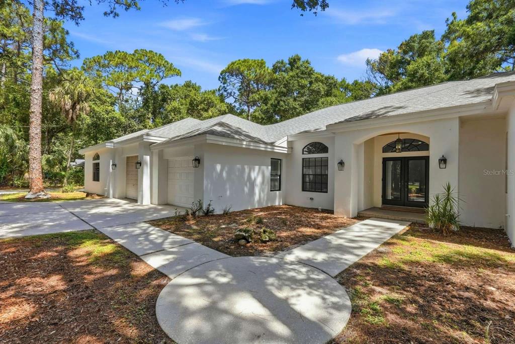 A white single-story house with a two-car garage and a paved walkway in front — 6301 S 86TH AVENUE N, PINELLAS PARK, FL