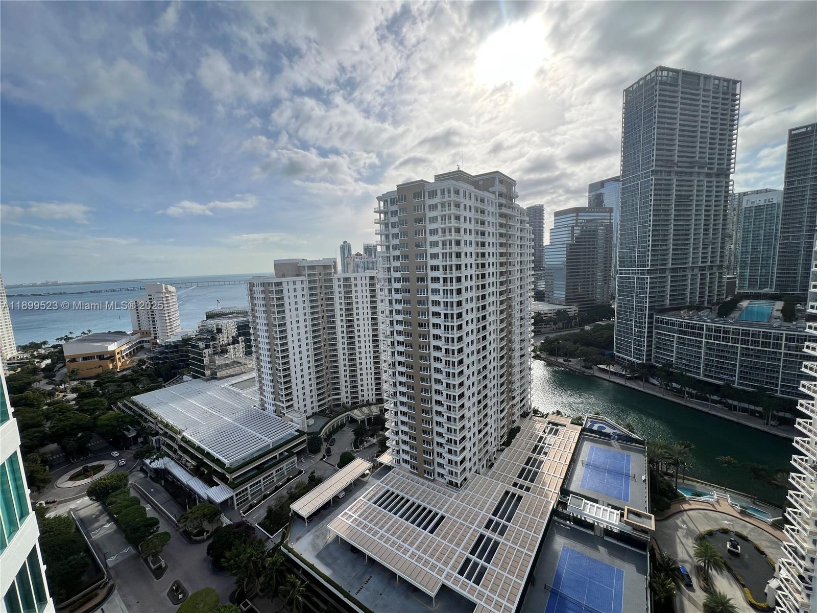 An elevated view shows multiple high-rise apartment buildings, a canal, and tennis courts in Miami — 900 Brickell Key Blvd # 2205, Miami FL 33131, MIAMI, FL