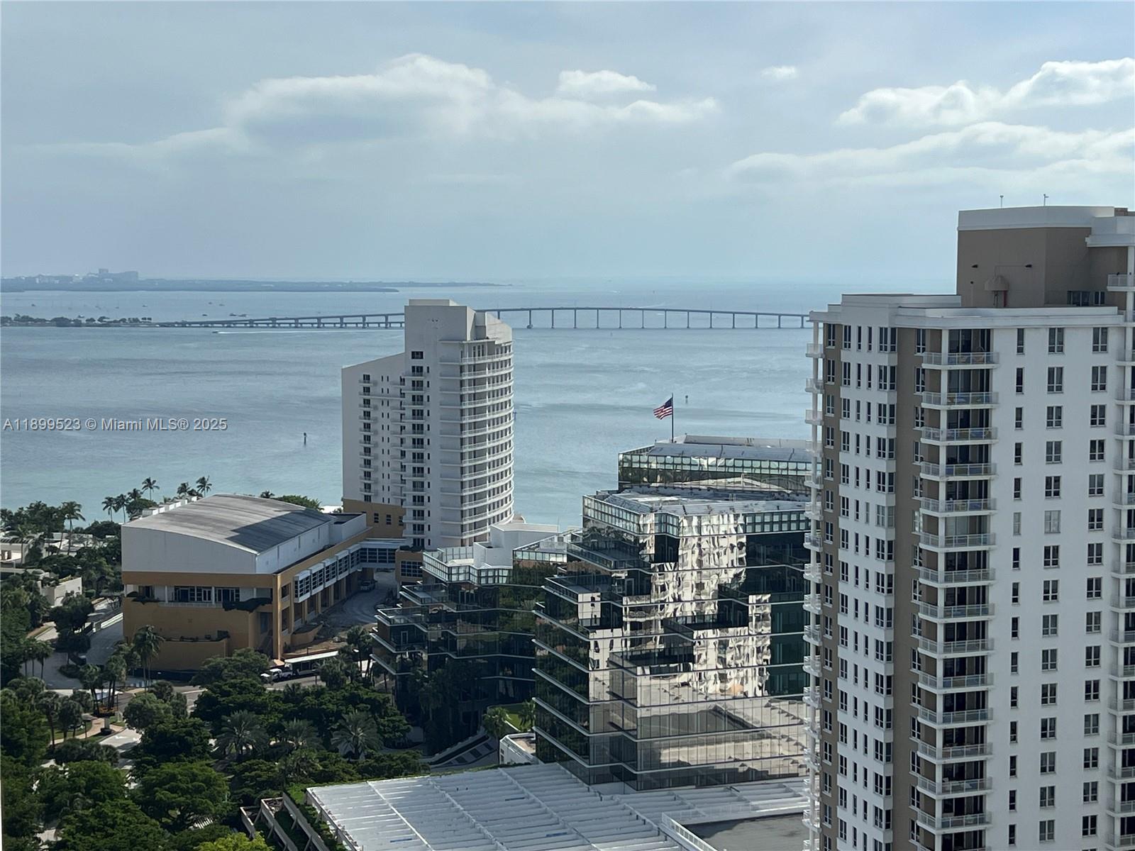 An elevated view of a coastal city skyline featuring high-rise buildings and a long bridge — 900 Brickell Key Blvd # 2205, Miami FL 33131, MIAMI, FL