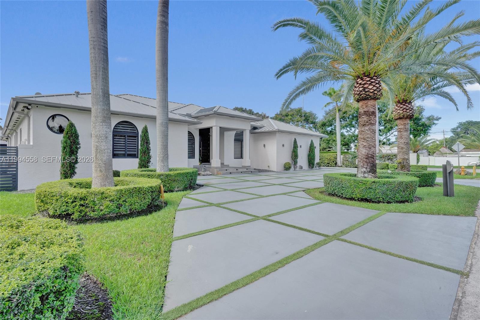 A single-story house with a concrete driveway featuring grass-filled grid patterns and palm trees — 2600 SW 128th Ct, Miami FL 33175, MIAMI, FL