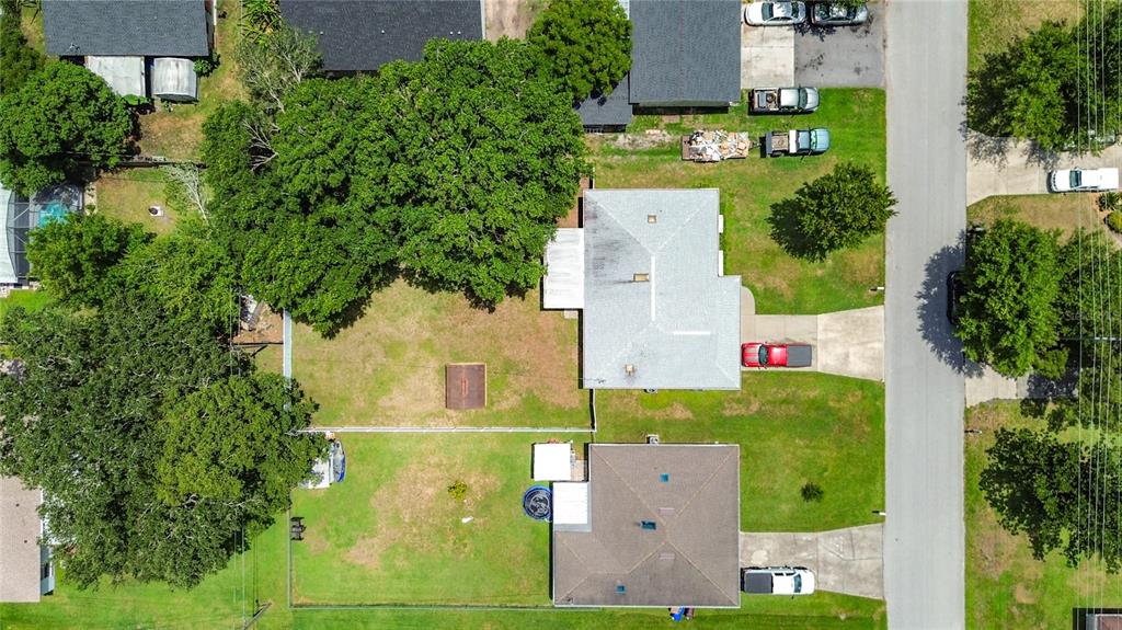An aerial view shows two adjacent houses with large backyards, mature trees, and driveways — 517 ILLINOIS AVENUE, ST CLOUD, FL