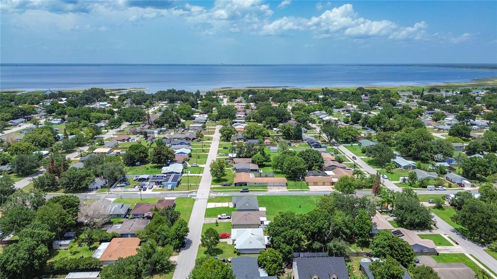 An aerial view shows a residential neighborhood situated along the shore of a large lake — 517 ILLINOIS AVENUE, ST CLOUD, FL