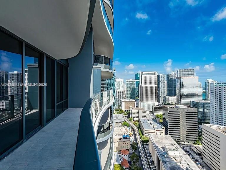 A high-rise balcony overlooks a dense urban skyline with numerous modern glass skyscrapers — 1000 Brickell Plz # 3509, Miami FL 33131, MIAMI, FL