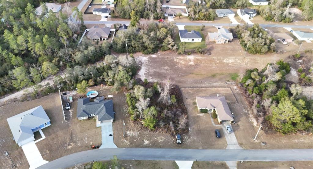 An aerial view shows several houses surrounded by wooded lots and a paved road — SW 159TH LANE ROAD UNIT 24, OCALA, FL
