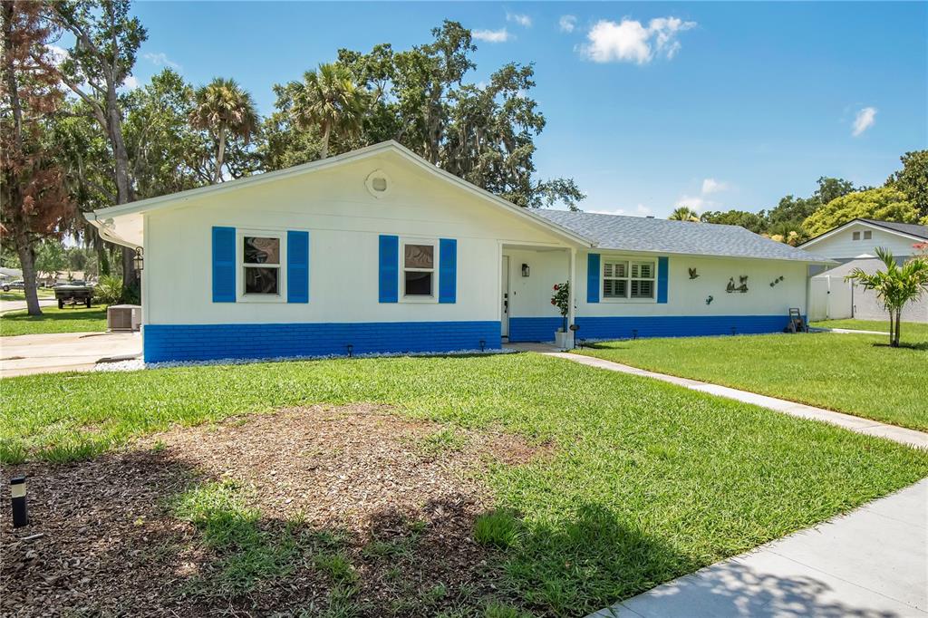 A single-story house with white siding, blue shutters, and a blue brick base — 944 BENTWOOD LANE, PORT ORANGE, FL