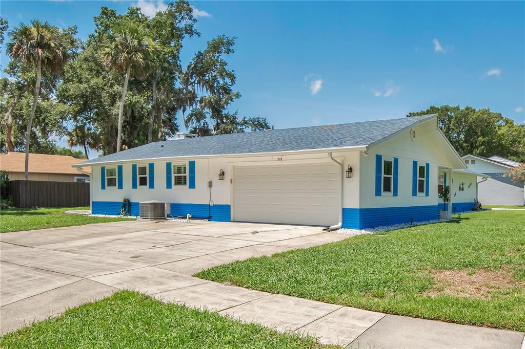 A single-story house with a white exterior, blue trim, and a two-car garage — 944 BENTWOOD LANE, PORT ORANGE, FL