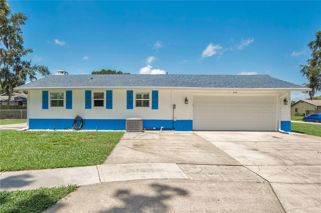 A single-story house with a white exterior, blue trim, and an attached two-car garage — 944 BENTWOOD LANE, PORT ORANGE, FL