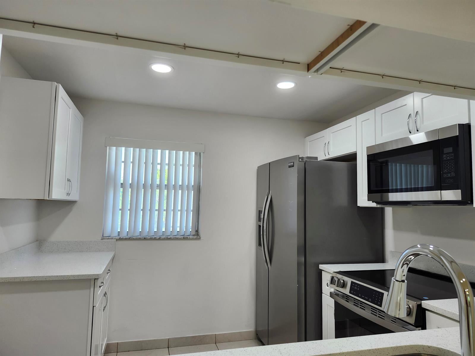 A kitchen featuring white cabinets, stainless steel appliances, and light-colored countertops — 330 NE 26th Avenue # 202, Boynton Beach FL 33435, BOYNTON BEACH, FL