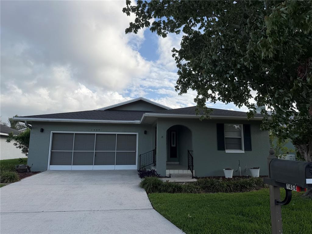 A single-story house with a gray exterior, a two-car garage, and a front entryway — 1454 GRAND CAYMAN CIRCLE, WINTER HAVEN, FL