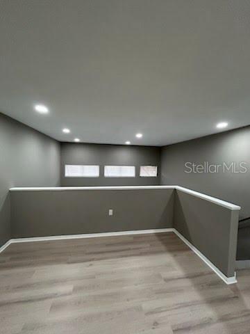 An upstairs loft area features gray walls, light wood-look flooring, and recessed ceiling lighting — 4010 DOLOMITE STREET UNIT A6, ORLANDO, FL