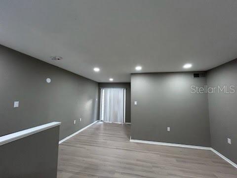 An empty living room with gray walls, recessed lighting, and light wood-look flooring — 4010 DOLOMITE STREET UNIT A6, ORLANDO, FL