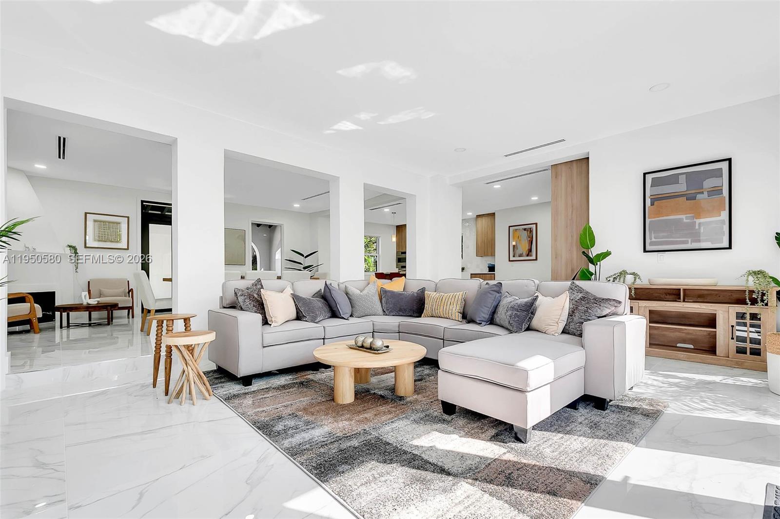 A bright living room features a large gray sectional sofa on a patterned area rug — 1702 Espanola Dr, Miami FL 33133, MIAMI, FL