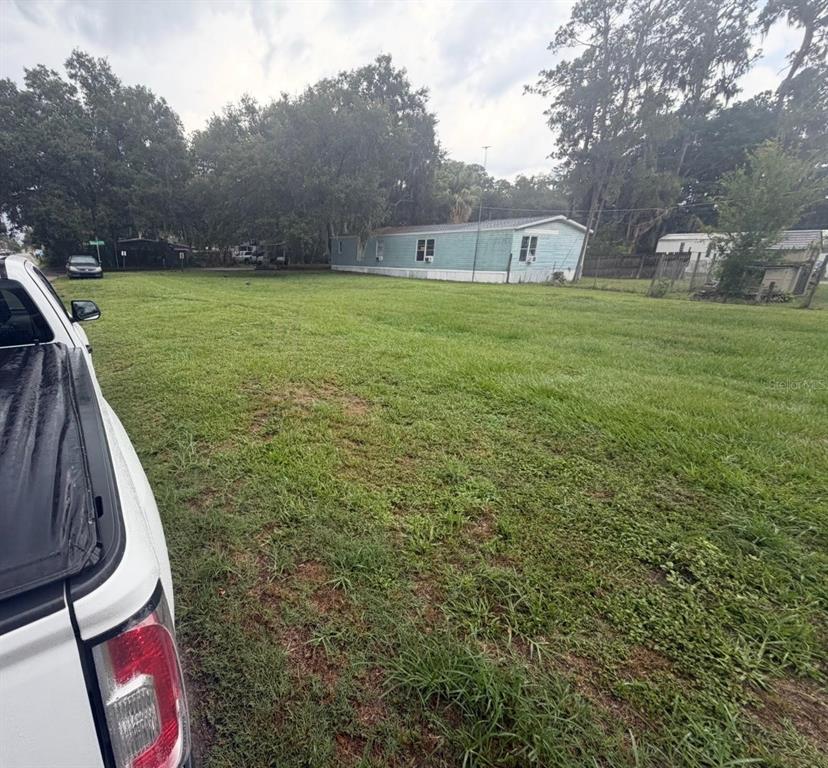 A white truck is parked on a grassy lot next to a light blue mobile home — 0 SUNSET CIRCLE, LAKE ALFRED, FL