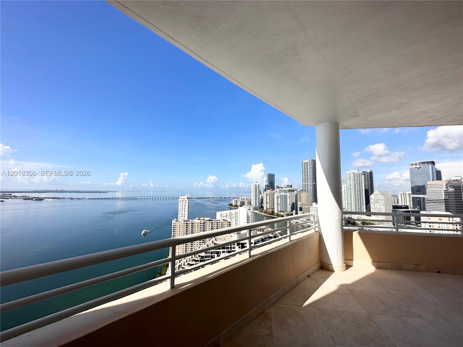 A high-rise balcony overlooks a bay with a city skyline and a bridge in the distance — 808 Brickell Key Dr # 3608, Miami FL 33131, MIAMI, FL