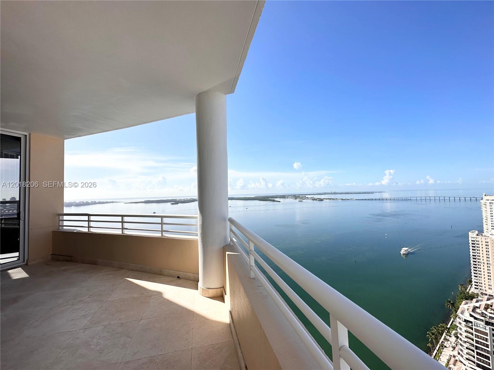 A high-rise balcony features a tiled floor, white railings, and a panoramic water view — 808 Brickell Key Dr # 3608, Miami FL 33131, MIAMI, FL