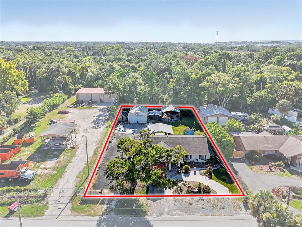 An aerial view shows a residential property with a house, outbuildings, and a large tree — 7813 LEO KIDD AVENUE, PORT RICHEY, FL