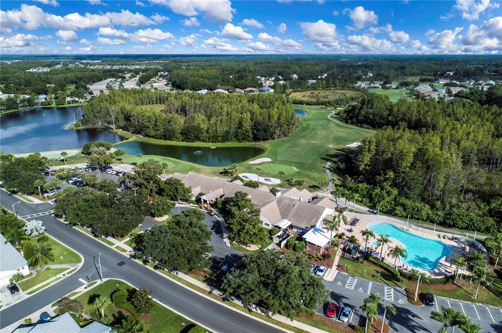An aerial view shows a clubhouse with a swimming pool, parking lot, and golf course — 20930 TANGOR ROAD, LAND O LAKES, FL
