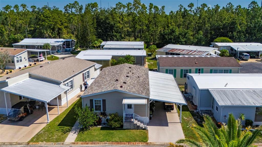 An aerial view shows several manufactured homes with carports and driveways in a residential community — 1000 KINGS HIGHWAY UNIT 54, PUNTA GORDA, FL