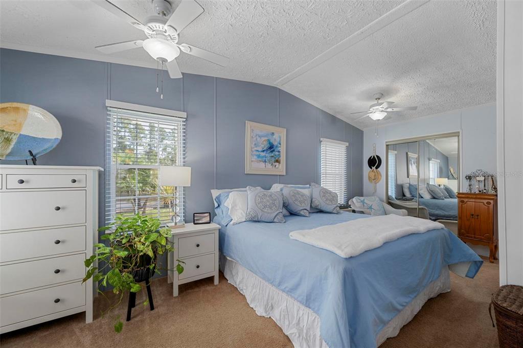 A bedroom with blue walls, a queen bed, white furniture, and a ceiling fan — 1000 KINGS HIGHWAY UNIT 54, PUNTA GORDA, FL