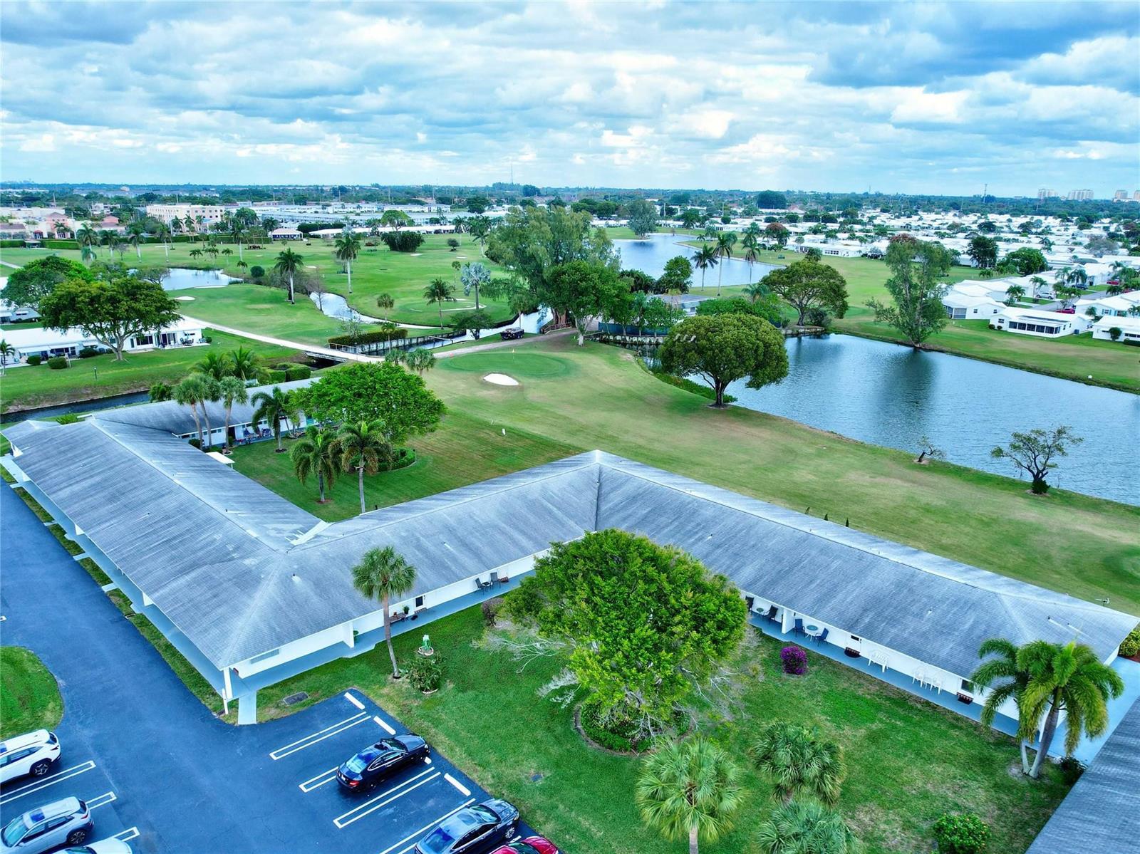 An aerial view shows an L-shaped building with a parking lot next to a golf course — 400 SW Golfview Terrace # 111, Boynton Beach FL 33426, BOYNTON BEACH, FL